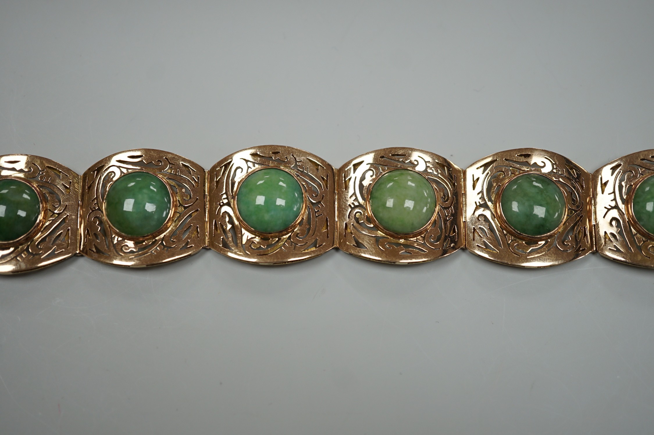 A continental 18k yellow metal and seven stone cabochon jade set bracelet, with pierced links, 18.5cm, gross weight 39.3 grams.